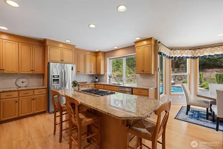 Gourmet kitchen with granite slab counter, stainless appliances and a walk-in panty.