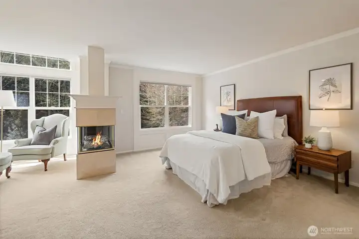 Primary suite with a gas fireplace, sitting area and a large walk-in closet.
