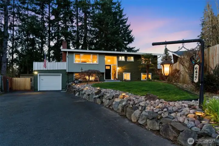 Path lights line the long front driveway to this completely remodeled home