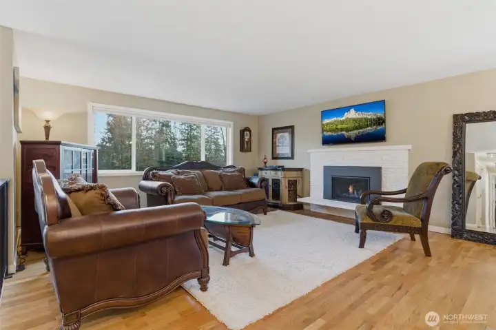 The spacious living area features a gas fireplace and a large picture window.