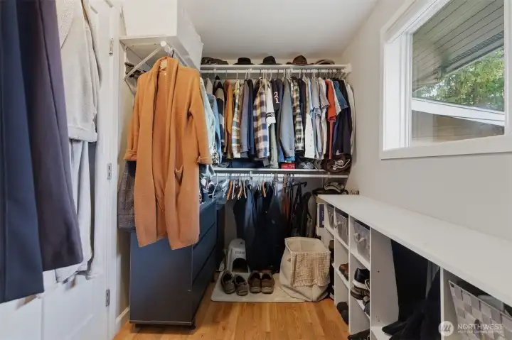 Large  primary bedroom walk-in closet with window. Photo shows 1/2 of closet.