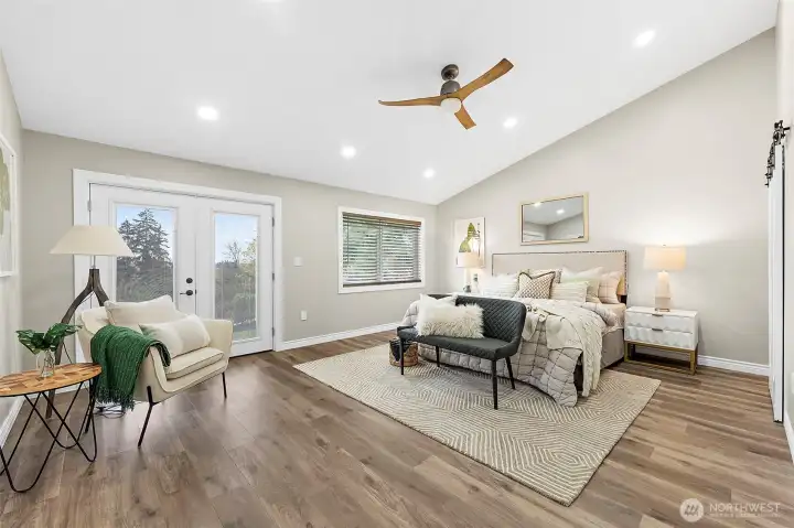 Large Primary bedroom with french doors to the lawn and gardens outside.