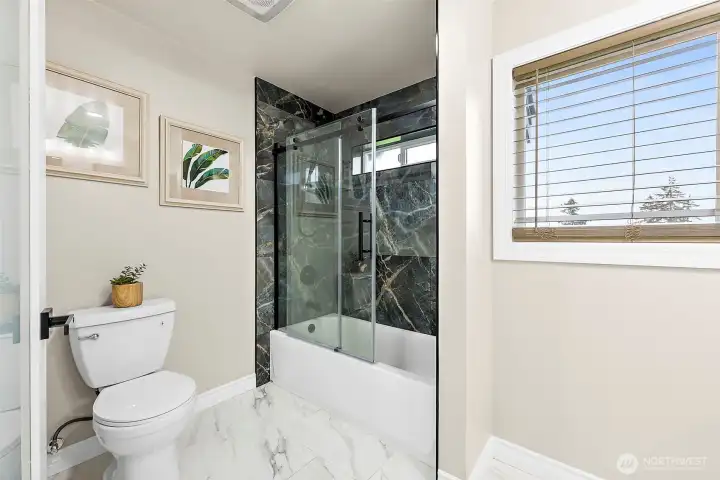 Main full bath for the other bedrooms and guests.  Marble surround and flooring to match the primary suite.