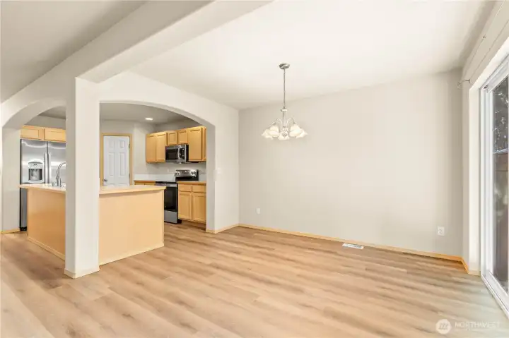DINING ROOM w/Archways into the Kitchen, New Laminate Floors and Slider to Back Patio. Curtain Rod stays.