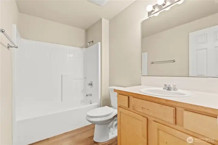 MAIN BATH w/Easy-Care Fiberglass Tub/Shower Combo, Laminate Floors and Full-Size Mirror.