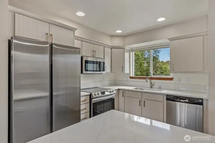Updated kitchen with quartz countertops. New Range and refrigerator. Updated kitchen with quartz countertops. New Range and refrigerator.