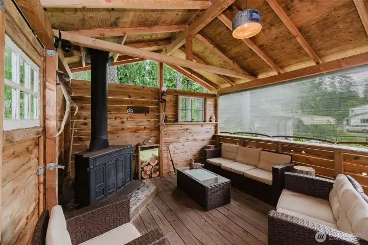 Combined with the saloon is a relaxed cabana designed for year-round enjoyment. A wood-burning stove keeps the space comfortable, while the rough-hewn bar top, comfortable seating area, and partially open-air design invite guests to linger. Combined with the saloon is a relaxed cabana designed for year-round enjoyment. A wood-burning stove keeps the space comfortable, while the rough-hewn bar top, comfortable seating area, and partially open-air design invite guests to linger.