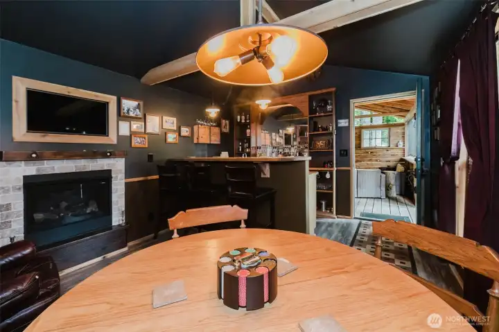 A custom bar with back bar, cozy gas fireplace, game table, oversized leather chair, exposed beams, vaulted ceiling, and even a mounted deer create an atmosphere that feels straight out of a mountain lodge and frontier hideaway all at once. A custom bar with back bar, cozy gas fireplace, game table, oversized leather chair, exposed beams, vaulted ceiling, and even a mounted deer create an atmosphere that feels straight out of a mountain lodge and frontier hideaway all at once.