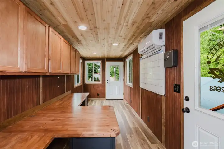 The standout feature is a unique two-story stacked shipping container setup. The lower container provides secure storage, while the upper level has been thoughtfully converted into a comfortable office or workspace complete with built-in desks, wood-paneled walls and ceilings, a mini-split heating and cooling system, and a covered deck overlooking the parking area below. The standout feature is a unique two-story stacked shipping container setup. The lower container provides secure storage, while the upper level has been thoughtfully converted into a comfortable office or workspace complete with built-in desks, wood-paneled walls and ceilings, a mini-split heating and cooling system, and a covered deck overlooking the parking area below.
