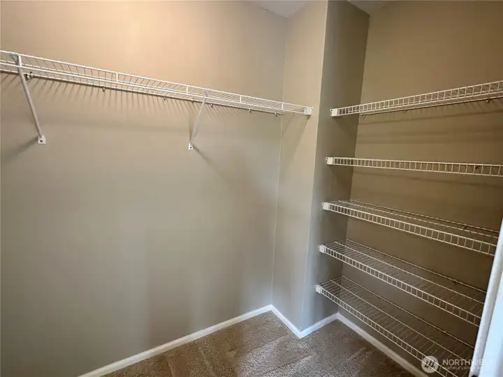 Organizers in the  primary walk-in-closet make life a little easier.