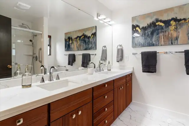 The primary suite bath is sleek in design and doubly delightful with its double sinks and walk-in shower.