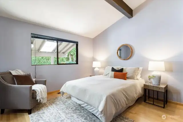 Vaulted ceilings and exposed wood beams bring a spacious bedroom into the realm of the truly remarkable.