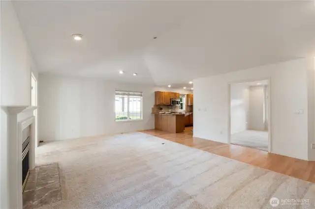 Living room shown as a blank canvas. Close proximity to the kitchen and dining room.