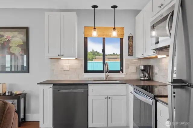 The kitchen has gourmet appliances, solid surface counters, and beautiful cabinetry.