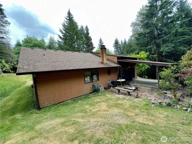 Side yard and view towards covered patio of the single level home at 818 NW 349th St, La Center WA in Clark County.