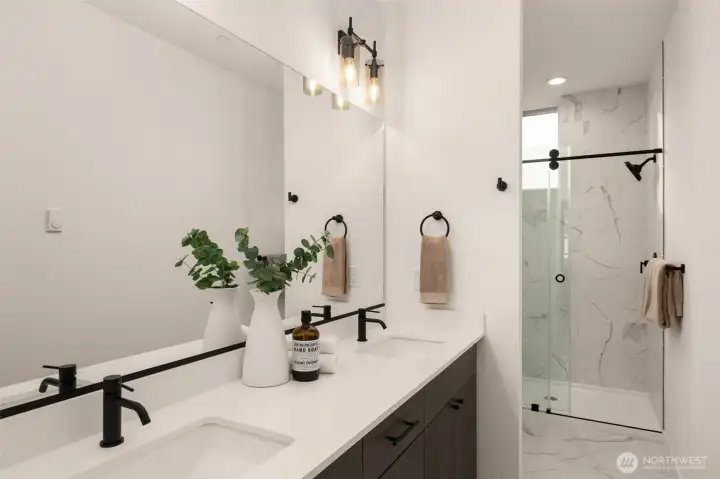 Ensuite bath includes a double sink vanity with a ceramic tile walk-in shower.