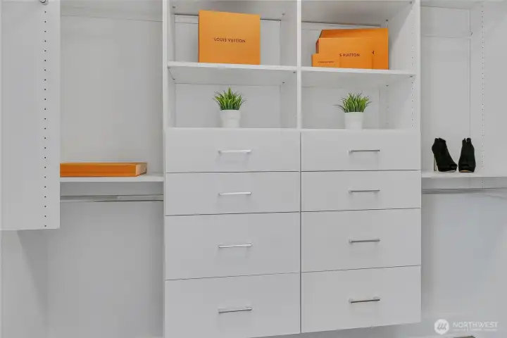 The walk-in closet features custom shelving.
