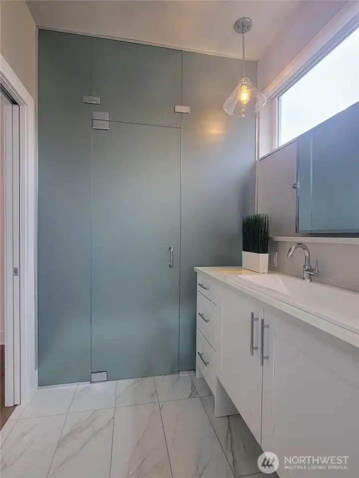 Primary bathroom featuring a frosted glass privacy enclosure.
