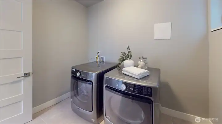 Spacious laundry room with side-by-side washer and dryer.