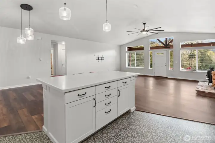 Large island opens to dining area, living room with a wood stove, large windows, lots of natural light!
