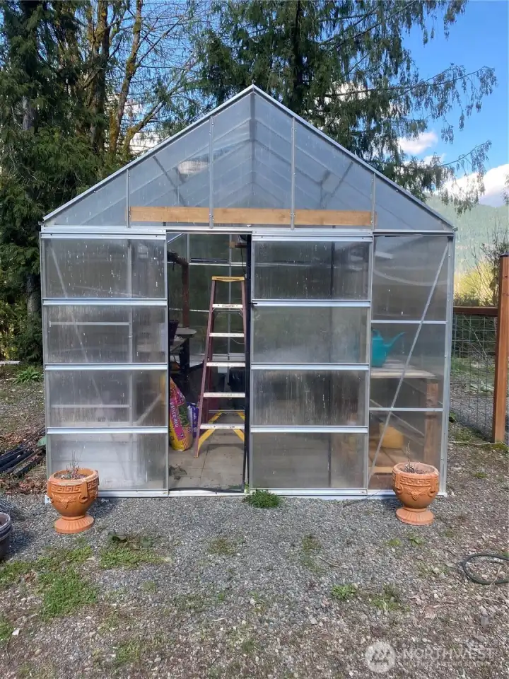 Year around gardening - green house features sliding doors, screens, industrial fan and shelves.