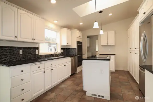 Stainless appliances, custom tile backsplash, granite countertops, tile floors and lots and lots of cabinets