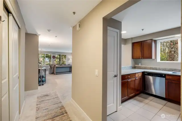 Welcoming entrance hallway leading into a spacious, light-filled living area and cozy kitchen with beautiful forest views. Step inside and feel right at home in this inviting corner unit condo!