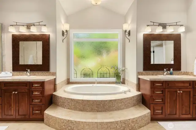 An extraordinary spa bathroom is the crowning touch in the primary suite. His and hers walk in closets and a jetted soaking tub with etched glass window are revealed upon opening the French paneled doors