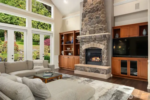 Great room offers souring 1.5 story floor to ceiling windows, custom stone to ceiling gas fireplace and custom built ins