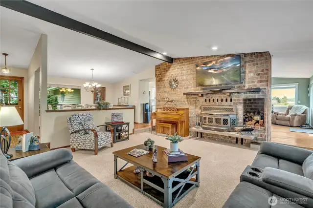 Living room with wood burning fireplace and views overlooing the manicured grounds and Mt Rainier