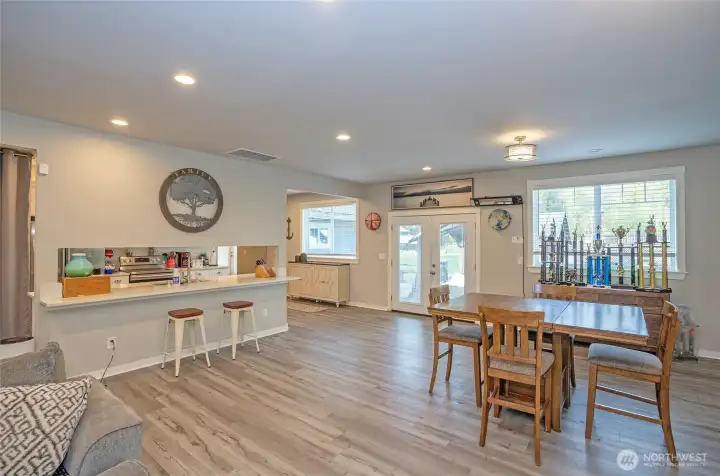 Expansive dining space flows to sliding doors, blending indoor comfort with outdoor charm