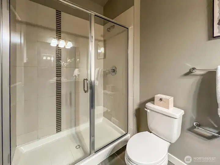 Large tiled shower in primary bathroom.