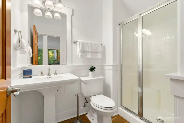 Powder room with shower for main level visitors to use.