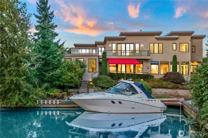 A beautiful look at the back of this majestic house. Direct from your dock through the canal to Lake Washington. House comes with the Yacht shown.