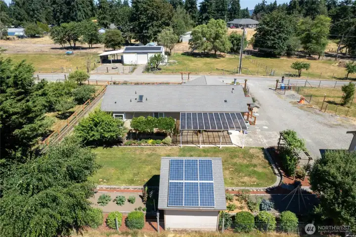 Solar panels can be seen on back side of garage and creative cottage. Beautiful double property- one lot with home and detached garage, pastures and horse arena and pastures and barn on other. Lot with barn structure is buildable for a home, plus ADU- buyer to verify to satisfaction. Rare opportunity in Tacoma!
