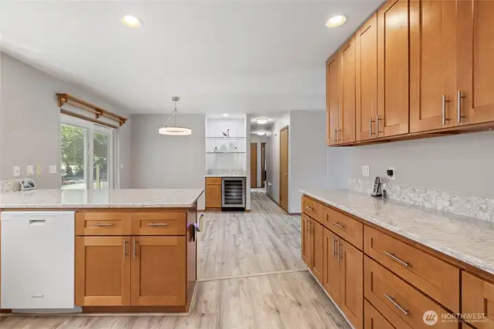 The kitchen was remodeled in 2023 and features quartz countertops, upgraded hardwood cabinetry, and durable LVP flooring. A built-in 48-bottle wine fridge completes the space.