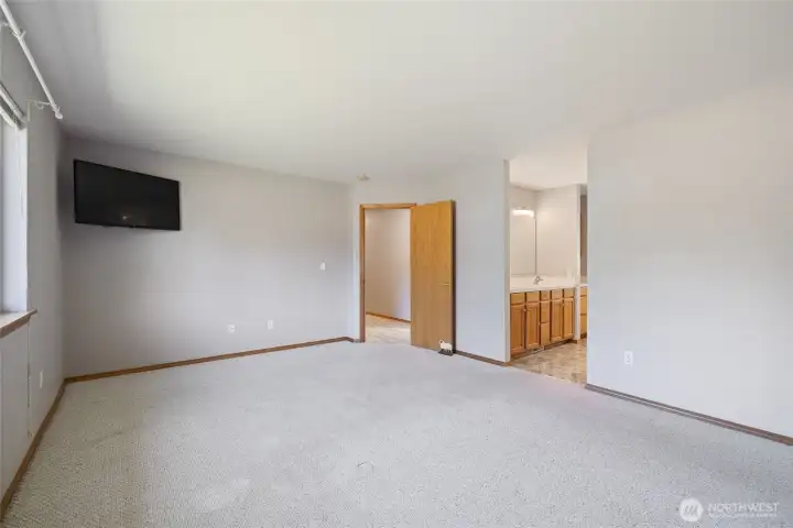 The primary suite is thoughtfully designed with custom California Closets and an ensuite bath. The bathroom features a six-foot soaking tub and a cable TV hookup, and all rooms in the home are wired for cable, including the primary bath.