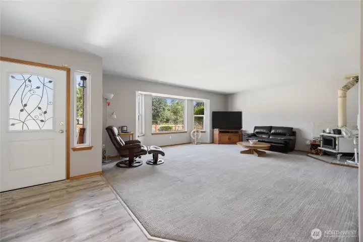 View of living room- Comfort was thoughtfully considered, with additional attic insulation, rigid metal ductwork, and insulated interior walls between living and bedroom spaces for sound dampening. A certified wood stove with a double-insulated pipe provides cozy ambiance and was professionally serviced in March 2025.