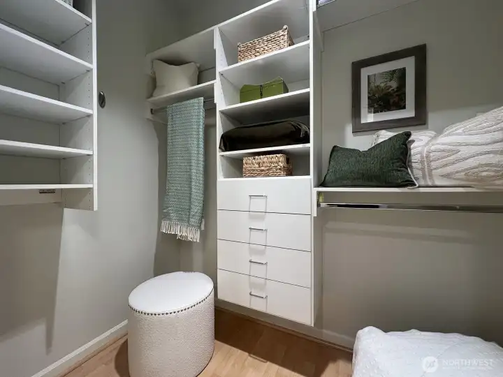 Primary bedroom walk-in closets with nice built ins and clothing racks.