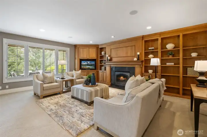 Large great room with gas fireplace and custom built-in cabinetry.