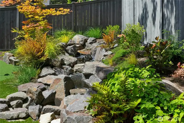 Custom waterfall feature is truly lovely, and located for enjoyment from the patio, yard and primary bedroom