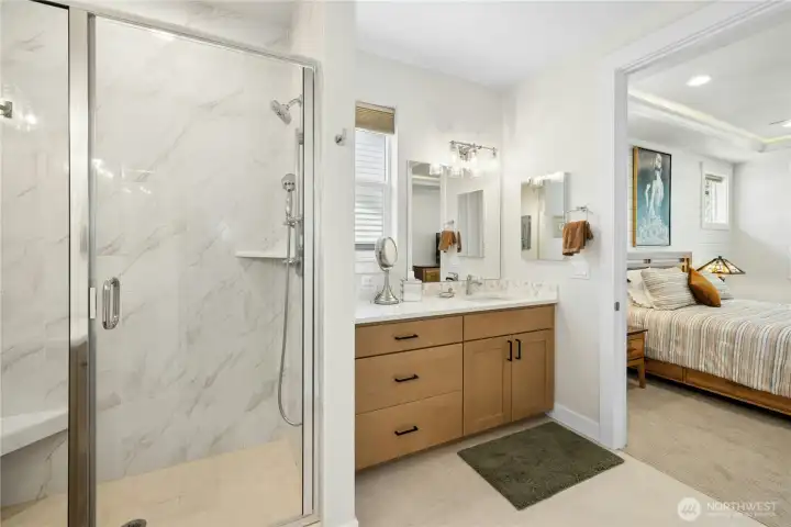 Primary bathroom with two separate vanities and walk in shower