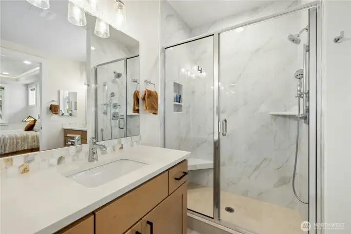 Walk in shower features upgraded tile shower pan, bench seat, niche & corner shelf