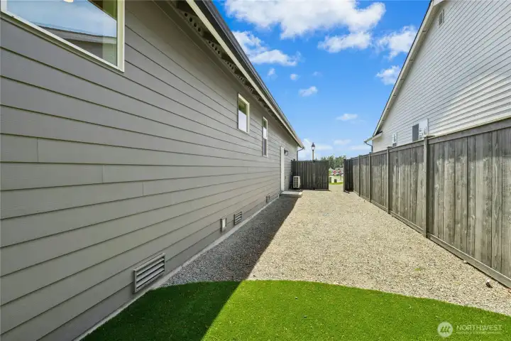West side yard, with garage man door and double gate. This area has irrigation for future planter boxes and space for parking toys.