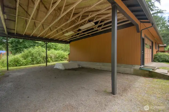 This generous carport sits right off the garage with great height.