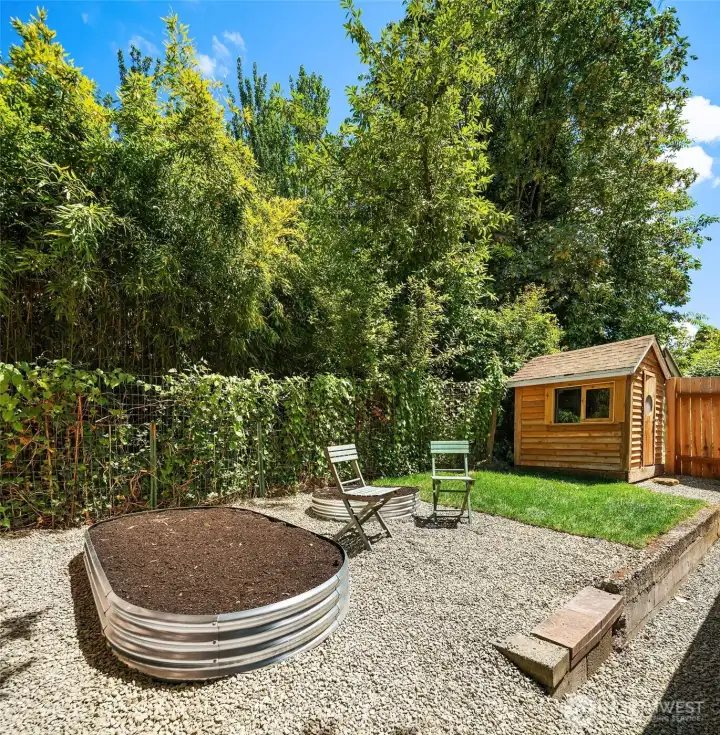Back yard is fenced with fresh gravel, sod, brand new raised beds for flowers and/or veggies and a sweet storage shed.