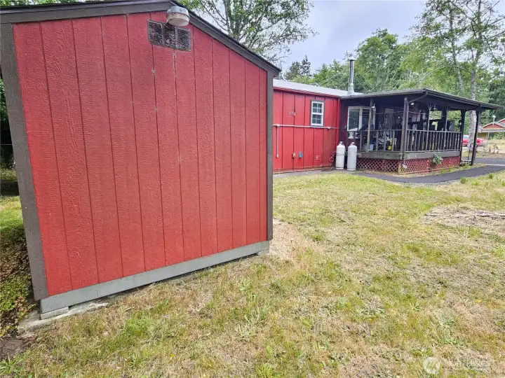 Photo taken from the back yard past the shed, showing the covered deck.