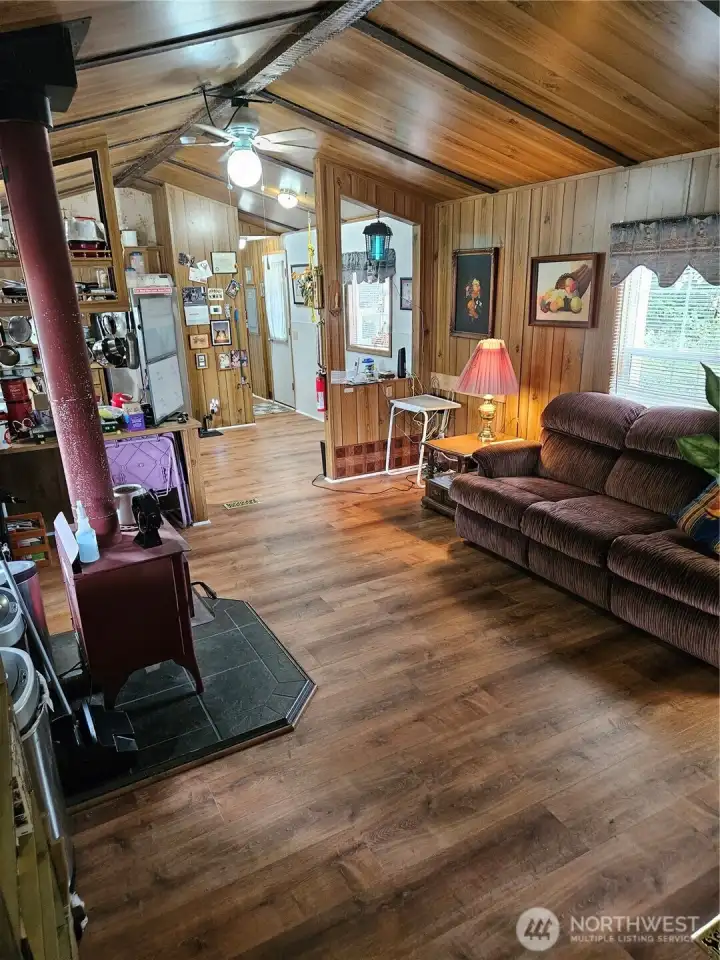 Expansive living area with new flooring throughout the house. Beautiful vaulted ceiling.  Wood burning stove.