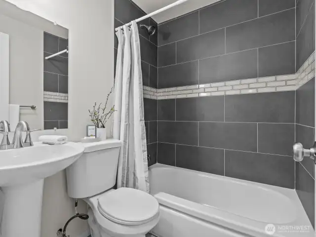 The stylish bathroom features the same flooring as the kitchen and this stunning tile.