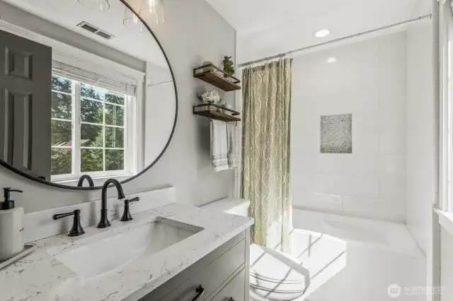 This stylishly appointed ensuite bathroom was redone in 2021 with new fixtures, toilet, tub, vanity and tile floors.